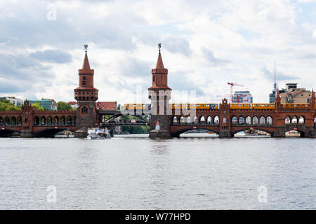 Oberbaumbrücke mit gelben Straßenbahn in Berlin vom Wasser aus gesehen. Stockfoto