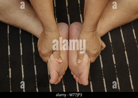 Behandlung von Verletzungen an den Füßen und Beinen mit einem Finger durch traditionelle Thai Massage. Stockfoto