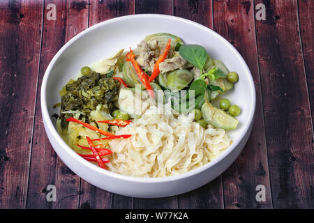 Beliebte Thailändische, chinesische Nudeln mit grünem Chicken Curry mit Kokosmilch nachgefüllt gehackte Essiggurke Kopfsalat. Stockfoto