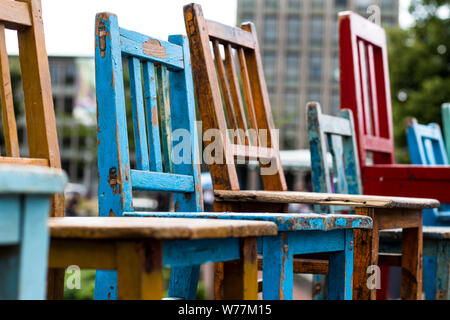 Aufstellung der bunten Stühle aus Holz in verschiedenen Größen auf einem Flohmarkt in Hannover, Deutschland Stockfoto