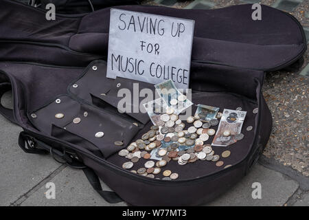 Von kaputtsparen redet bis zur Hochschule für Musik". Ein junger Musiker busks in der Oxford Street in London, UK. Stockfoto