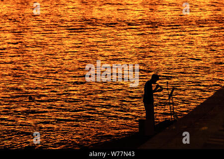 (190805) - HARBIN, August 5, 2019 (Xinhua) - ein Bürger ist im Sonnenuntergang entlang der Songhua Fluss in Harbin, die Hauptstadt der Provinz Heilongjiang im Nordosten Chinas, 31. Juli 2019. Durch die Kühle im Sommer angezogen, viele Touristen kommen nach Harbin für Urlaub. In der Zwischenzeit, Harbin ist eine Stadt der Musik für die Einheimischen, die in Kontakt mit der europäischen Klassik in einer früheren Zeit in China erhielt. Mit der kühlen Sommer und reiche Kultur, Harbin empfangen 36.23 Millionen Touristen und machte einen Umsatz von 60,7 Milliarden Yuan (8,6 Milliarden US-Dollar) im Sommer 2018. (Xinhua / Xie Jianfei) Stockfoto