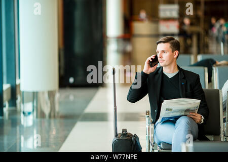 Urban Business Mann auf Smart Phone im Inneren im Flughafen. Stockfoto