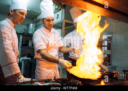 Feuer in der Küche. Feuer Gas verbrennen ist Kochen auf eiserne Pfanne, rühren sie Feuer sehr heiß. Stockfoto