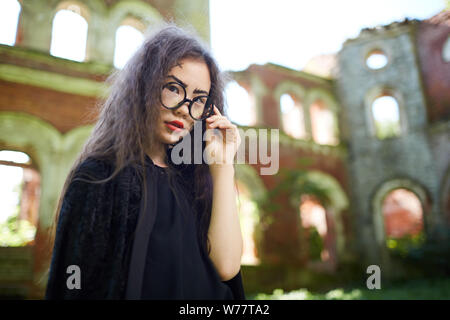 Portrait von Teenage asiatischen Mädchen gekleidet als Hexe in verlassenen Burg auf Halloween Posing, kopieren Raum Stockfoto