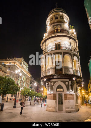 Ein traditionelles verzierten Gebäude- und Mehrfamilienhaus in der Altstadt von Sevilla Spanien in der Nacht beleuchtet durch Straßenbeleuchtung und Innenbeleuchtung Stockfoto