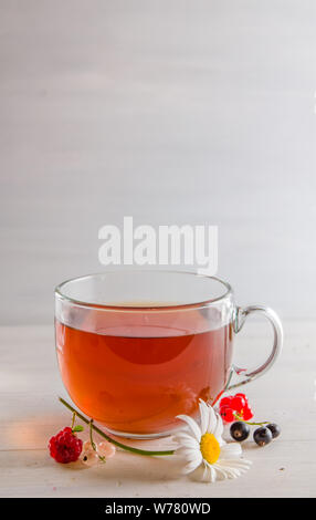 Tee in eine Tasse mit Beeren und Kamille auf weißem Hintergrund mit Kopie Raum Stockfoto