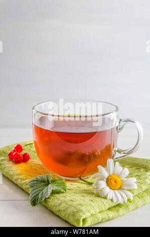 Tee in eine Tasse mit Beeren und Kamille auf weißem Hintergrund mit Kopie Raum Stockfoto