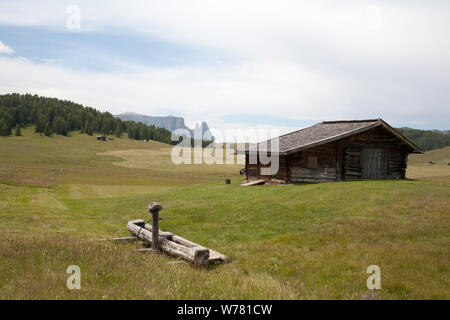 Viehstall und Heuwiesen auf der Seiser Alm Und Die Schlern Schlern Und Santnar Spitze Im Hintergrund Wolkenstein Gröden Italien Stockfoto