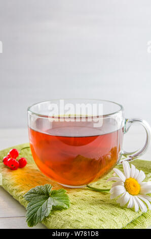 Tee in eine Tasse mit Beeren und Kamille auf weißem Hintergrund mit Kopie Raum Stockfoto