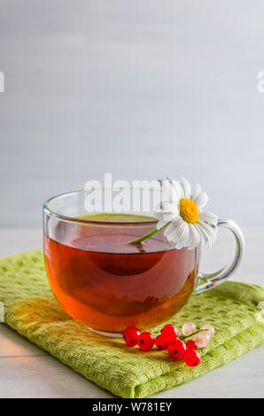 Tee in eine Tasse mit Beeren und Kamille auf weißem Hintergrund mit Kopie Raum Stockfoto