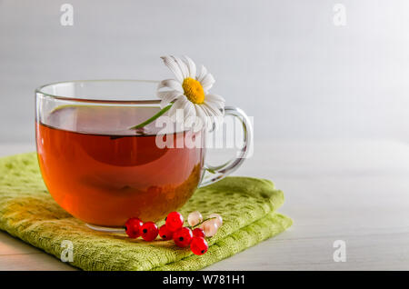 Tee in eine Tasse mit Beeren und Kamille auf weißem Hintergrund mit Kopie Raum Stockfoto