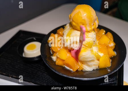 Mango Obst rasiert Eis und Mango Eis Milch Geschmack mit Sirup servieren Stockfoto