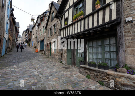 Malerische Straße mit Kopfsteinpflaster und alten Fachwerkhaus und Stein Gebäude Gebäude in der Altstadt von Dinan in der Bretagne, Frankreich Stockfoto