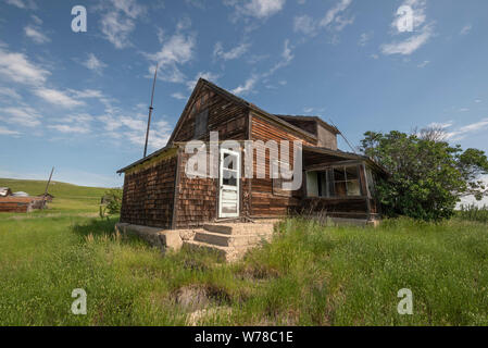 Verlassenen Bauernhaus auf der offenen Wiese im südlichen Saskatchewan. Stockfoto