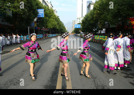 Anwohner in traditionellen Kostümen und headwears gekleidet werden, nehmen an einer Parade zum 30. Jahrestag der Errichtung des Yinjiang zu feiern. Stockfoto