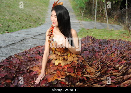 Eine chinesische Modell trägt ein zwei Meter langes Kleid aus Crepe myrthen Blätter stellt auf einem Blatt fashion show in Shampoola Forest Resort in Qingyuan Stadt, Stockfoto