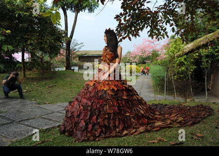 Eine chinesische Modell trägt ein zwei Meter langes Kleid aus Crepe myrthen Blätter stellt auf einem Blatt fashion show in Shampoola Forest Resort in Qingyuan Stadt, Stockfoto