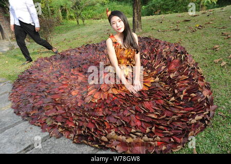 Eine chinesische Modell trägt ein zwei Meter langes Kleid aus Crepe myrthen Blätter stellt auf einem Blatt fashion show in Shampoola Forest Resort in Qingyuan Stadt, Stockfoto