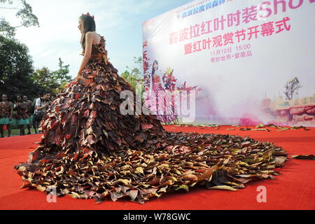 Eine chinesische Modell trägt ein zwei Meter langes Kleid aus Crepe myrthen Blätter stellt auf einem Blatt fashion show in Shampoola Forest Resort in Qingyuan Stadt, Stockfoto