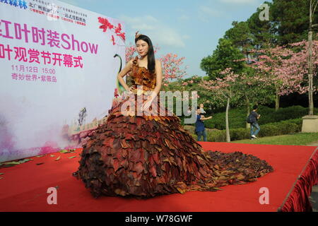 Eine chinesische Modell trägt ein zwei Meter langes Kleid aus Crepe myrthen Blätter stellt auf einem Blatt fashion show in Shampoola Forest Resort in Qingyuan Stadt, Stockfoto