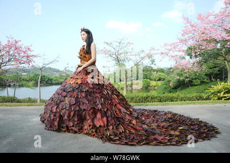 Eine chinesische Modell trägt ein zwei Meter langes Kleid aus Crepe myrthen Blätter stellt auf einem Blatt fashion show in Shampoola Forest Resort in Qingyuan Stadt, Stockfoto