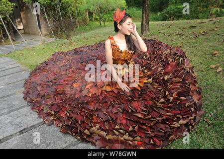 Eine chinesische Modell trägt ein zwei Meter langes Kleid aus Crepe myrthen Blätter stellt auf einem Blatt fashion show in Shampoola Forest Resort in Qingyuan Stadt, Stockfoto