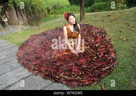 Eine chinesische Modell trägt ein zwei Meter langes Kleid aus Crepe myrthen Blätter stellt auf einem Blatt fashion show in Shampoola Forest Resort in Qingyuan Stadt, Stockfoto