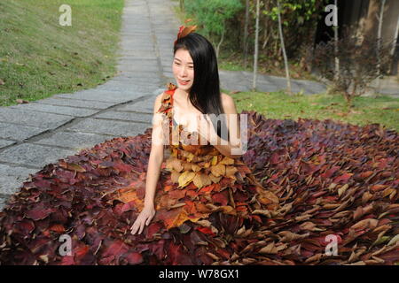 Eine chinesische Modell trägt ein zwei Meter langes Kleid aus Crepe myrthen Blätter stellt auf einem Blatt fashion show in Shampoola Forest Resort in Qingyuan Stadt, Stockfoto