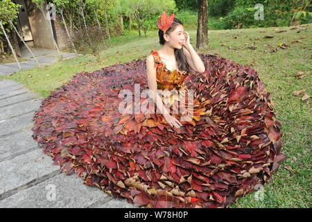 Eine chinesische Modell trägt ein zwei Meter langes Kleid aus Crepe myrthen Blätter stellt auf einem Blatt fashion show in Shampoola Forest Resort in Qingyuan Stadt, Stockfoto