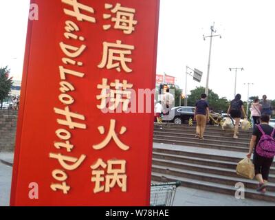 ---- Fußgänger vorbei an einem Namensschild von Hai Di Lao Hotpot in Peking, China, 28. Mai 2016. Haidilao Eintopf, der Restaurant kette, führt die Stockfoto