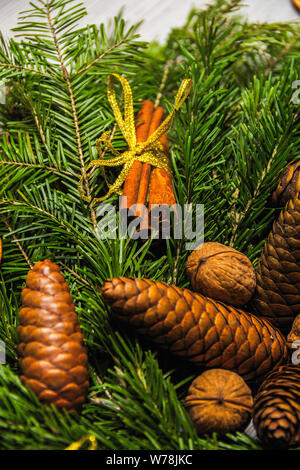 Urlaub das Neue Jahr Dekorationen. Handgefertigte Weihnachten Kranz aus Tannenzweigen mit Nüssen, Zimt und getrocknete Früchte bestäubt mit künstlichem Schnee Stockfoto