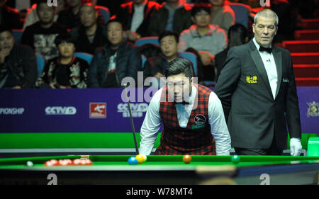 Yan Bingtao China hält einen Schuß zu John Higgins von Schottland in ihrem Viertelfinale während der 2017 Internationale Meisterschaft snooker Tour Stockfoto