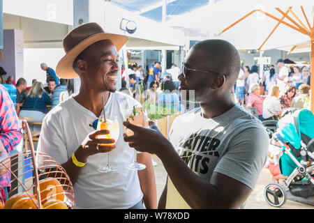 Johannesburg, Südafrika - 14. Oktober 2017: Afrikanische männlichen Freunden trinken und in der Regel genießen Sie einen Tag auf einer Messe Essen und Wein trinken und Gen Stockfoto