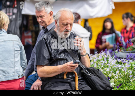 Cambridge, UK, 1. August 2019. Bärtige ältere Menschen gechillt und das Rauchen auf der Straße Stockfoto
