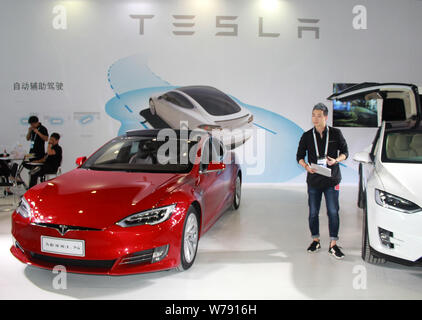 --FILE - Ein Mitarbeiter wird dargestellt, neben einem Tesla Model S Elektroauto auf dem Display während ein Expo in Nanjing, Provinz Jiangsu im Osten Chinas, 2. September Stockfoto