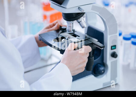 Nahaufnahme von einem Biologen Arbeiten mit dem Mikroskop. Stockfoto