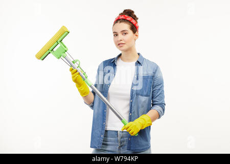 Pretty Woman in Arbeitskleidung hält eine gelbe Stock Mop. Stockfoto