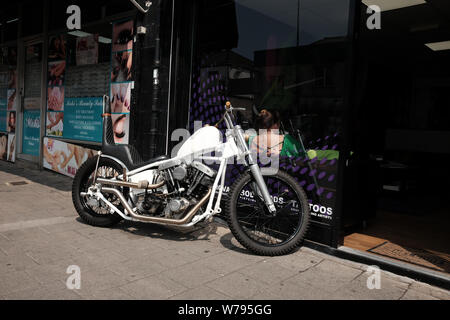 Juli 2019 - Weiß Harley Davidson Chopper Motorrad außerhalb ein Shop in Cardiff, Wales, UK. Stockfoto