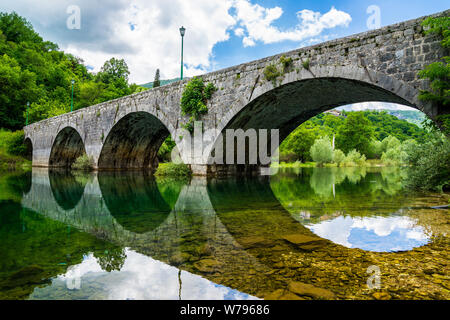 Montenegro, schöne alte steinerne Brücke über den Fluss crnojevica in der Nähe der Stadt Cetinje in Skadar Lake National Park in Stille spiegelglatte Wasser widerspiegeln Stockfoto