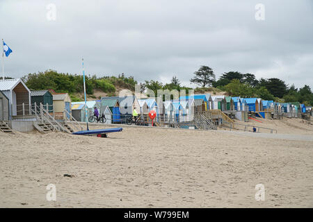 Eine Linie der Umkleidekabinen am Strand an einem bewölkten Tag in Abersoch, Wales, Großbritannien Stockfoto