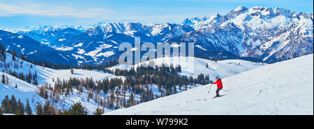 GOSAU, Österreich - 26. FEBRUAR 2019: Panorama der schneebedeckten Hang mit einsamen weiblichen Skifahrer, Downhill von zwieselalm Berg in Dachstein West ein Stockfoto