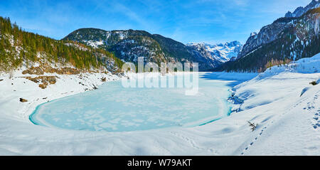 Panorama der Flauschig verschneiten Deich Gosausee, die mit Eis und Raureif überzogen ist und durch die sehr großen Dachstein Alpen umgeben, Gosau, Austr Stockfoto