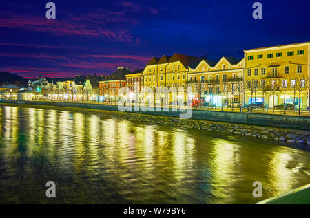 BAD ISCHL, Österreich - Februar 26, 2019: Dark twilight Himmel über der Altstadt; historische Häuser, entlang Damm, sind in den Gewässern von T wider Stockfoto