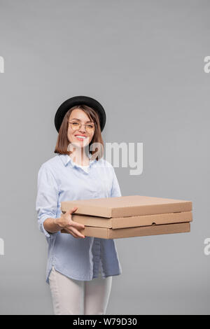 Glückliche junge casual Frau mit Stapel von Kartonverpackungen Stockfoto