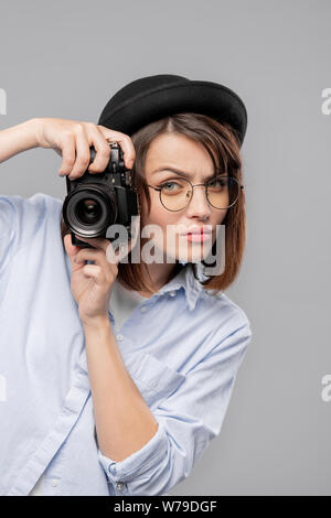 Junge schwere Fotografin mit Kamera konzentriert sich auf die Shot Stockfoto