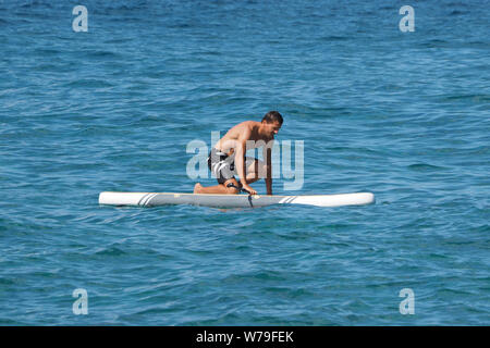 Mann bekommt auf dem Paddle Board. Stockfoto