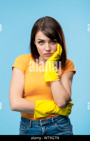 Junge krank oder verärgert Frau im gelben Gummihandschuhe und t-shirt Stockfoto