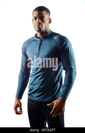 Schöne attraktive Sportler schaut gerne zur Kamera, hat gute Laune, als er eine neue trendige Sportswear gekauft hat. isoliert weißer Hintergrund, Studio gedreht. Stockfoto