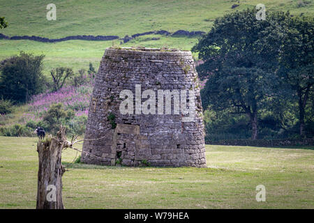 Aufgegebenen, abgebrochenen alten Stein Windmühle iOverlooked durch die Moderne Carsington Windpark Turbinen auf dem High Peak Trail in Brassington, Derbyshire UK Stockfoto